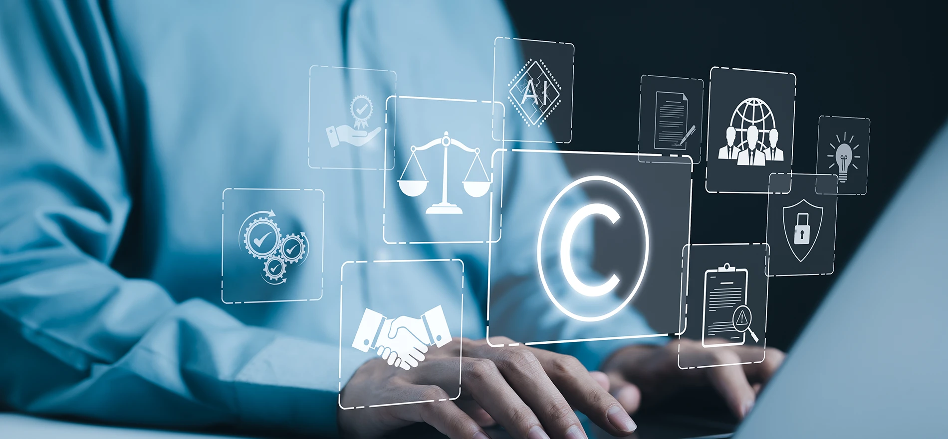 Person typing on a laptop with holographic overlays featuring a copyright symbol, scales of justice, and digital security icons
